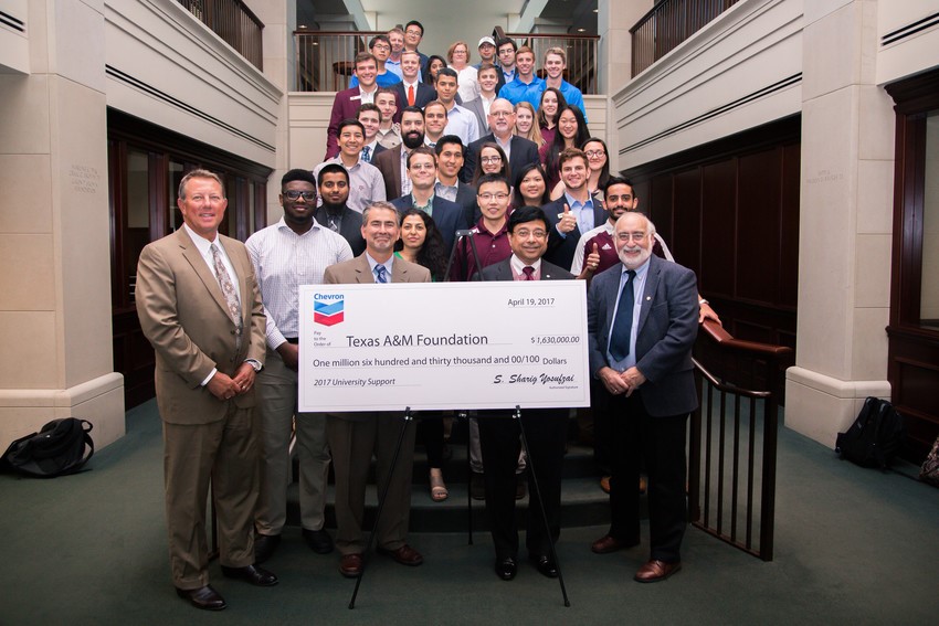 large group of people holding large ceremonial check